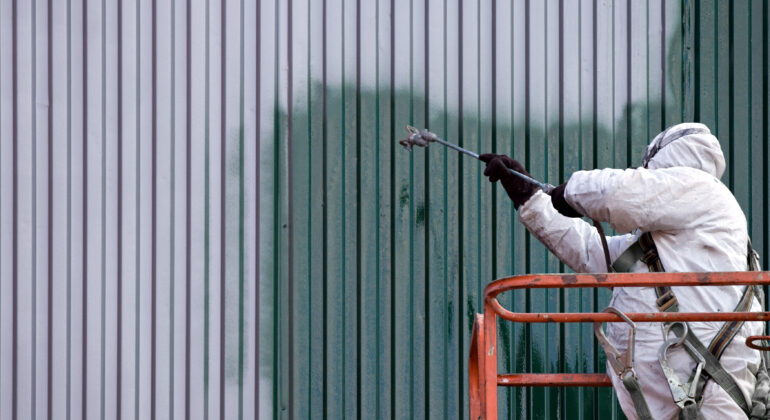 commercial painter on a lift spraying paint